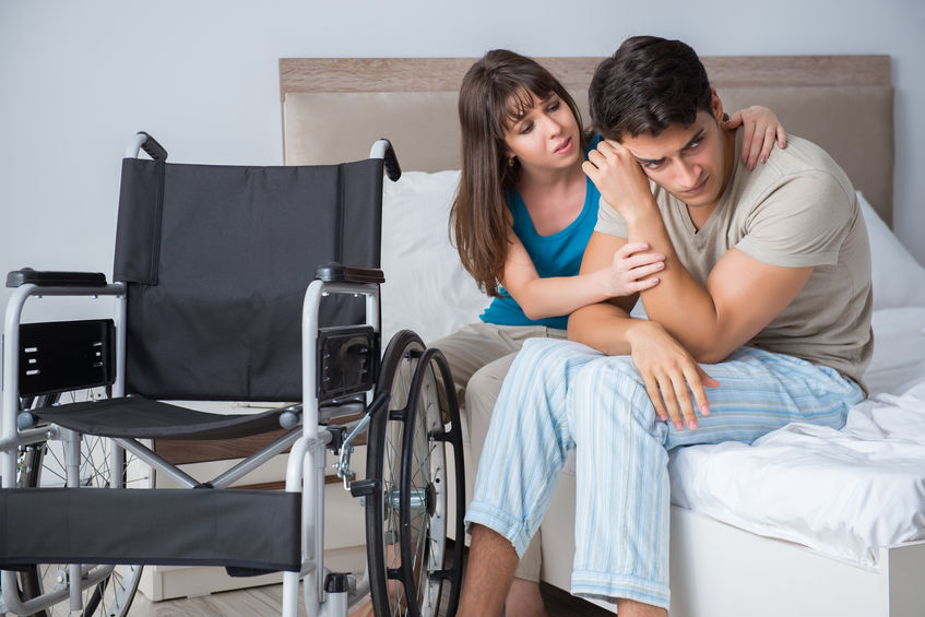 woman consoling young man in wheelchair
